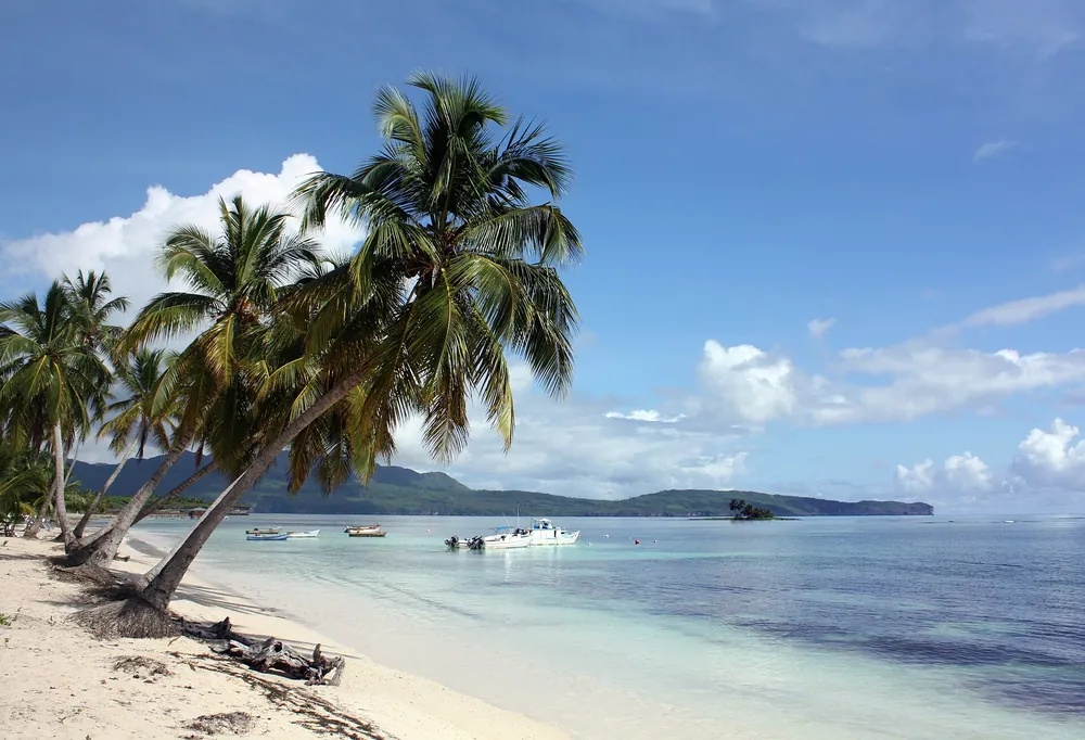 Caribbean beach with palm trees and boats at a cruise destination island